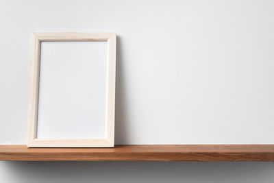 Close-up of empty table against wall at home