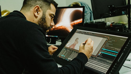 Side view of man using laptop at office