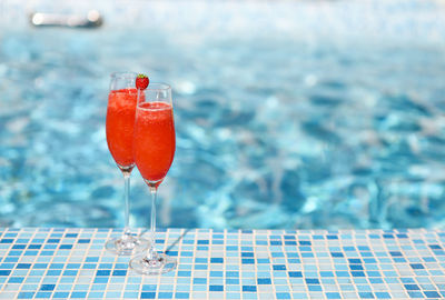 Close-up of drink on table against swimming pool