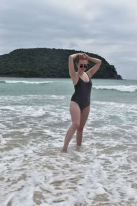 Full length of young woman standing on beach