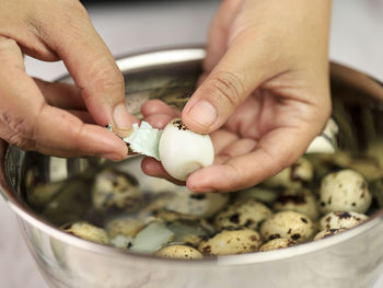 Asian old woman hand peel quail egg