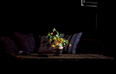 Flower vase on table against sofa at home