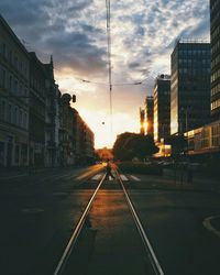 Railroad tracks against cloudy sky