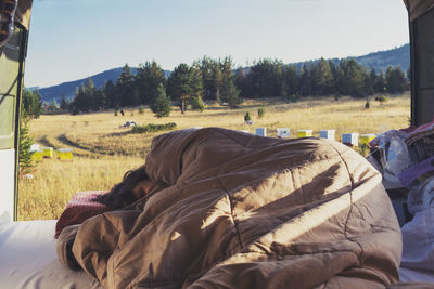 Close-up of person lying on field against sky