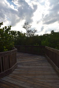 View of footbridge against cloudy sky