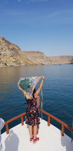 Rear view of woman looking at sea against sky