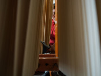 Side view of woman looking through window