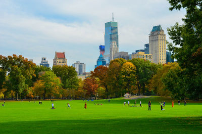People at central park with city buildings seen in background