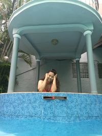 Woman sitting in swimming pool