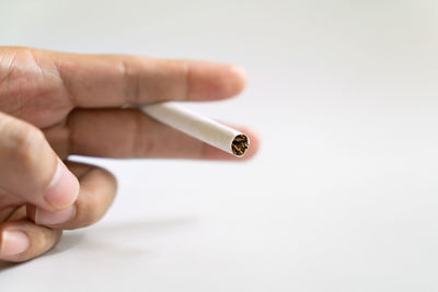 Close-up of hand holding cigarette