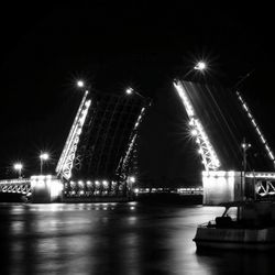 Illuminated bridge over river at night