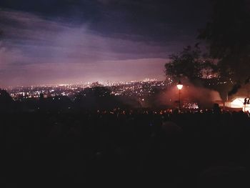 Crowd in city against sky at night