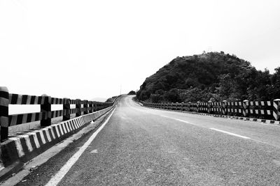 Road amidst trees against clear sky