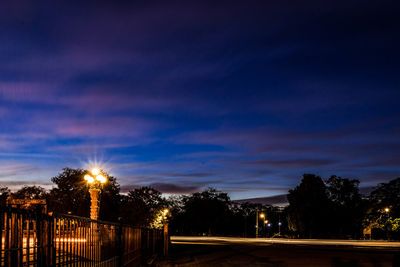 Low angle view of illuminated trees against sky at night