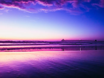 Scenic view of beach against sky at sunset