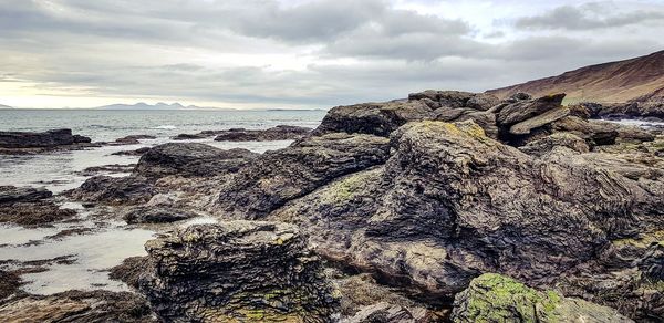 Rock formations on sea shore against sky