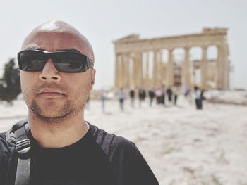 Portrait of man wearing sunglasses against acropolis