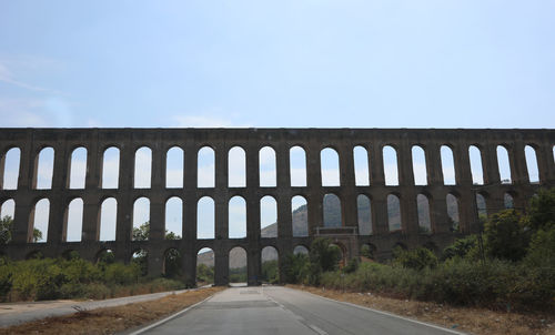 View of empty road against clear blue sky