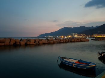 Boats in sea against sky during sunset