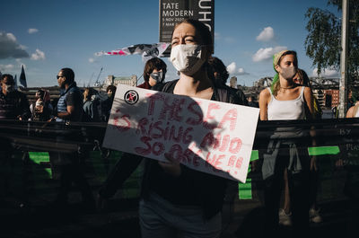 People standing against sky in city