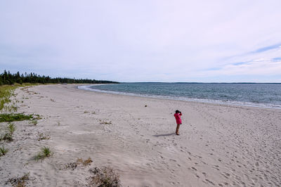 Man standing on beach by sea against sky