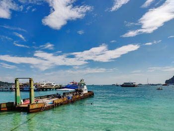 View of boats in sea against cloudy sky