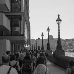 Group of people in front of buildings against clear sky