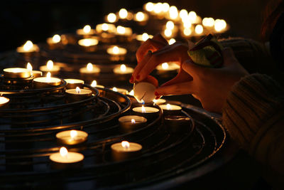 Cropped hands of woman lightning candles