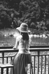 Rear view of woman standing against railing