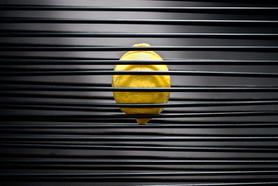 Close-up of lemon amidst metal grate