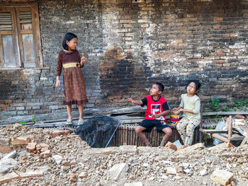 Full length of a young couple sitting outdoors