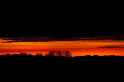 Scenic view of silhouette landscape against orange sky