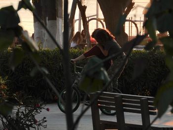 Woman sitting on bench in park