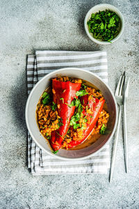 From above stuffed bell peppers stewed in stone pan with tomato sauce