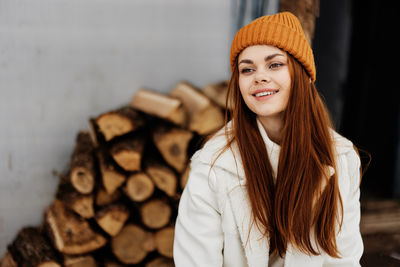 Portrait of young woman standing against wall