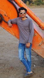 Portrait of young man standing by machinery