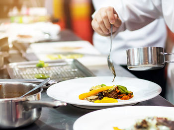 Midsection of woman having food on table