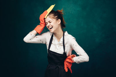 Cheerful young woman against green background