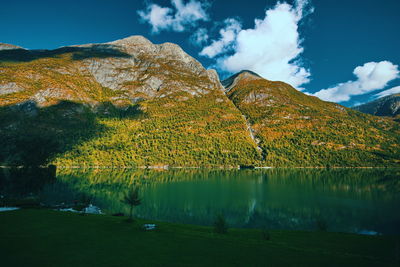 Scenic view of lake by mountain against sky