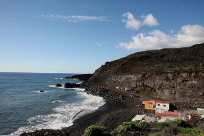 Scenic view of sea by buildings against sky