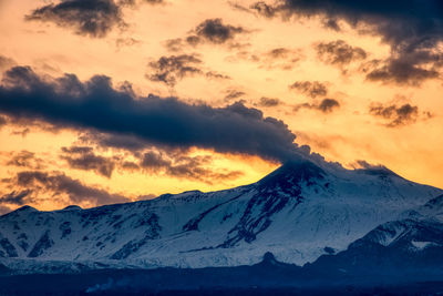 Panoramic view of the snow capped etna volcano against the sky during sunset