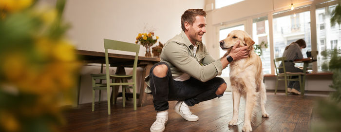 Side view of woman with dog standing in gym