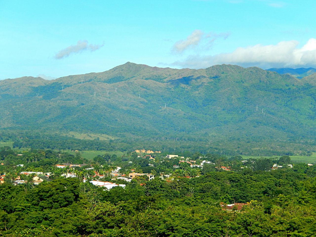 AERIAL VIEW OF BUILDINGS AND MOUNTAINS AGAINST SKY