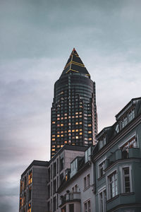 Low angle view of buildings against cloudy sky