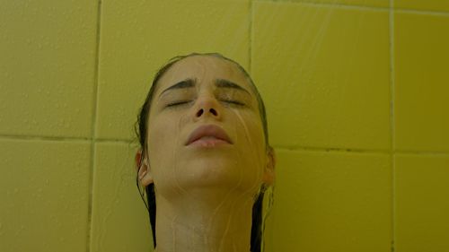 Portrait of young woman against wall