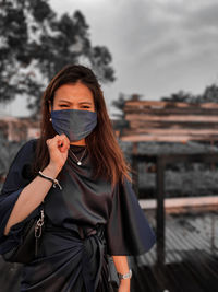 Portrait of beautiful woman standing against sky