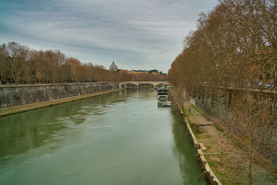 Canal amidst trees against sky