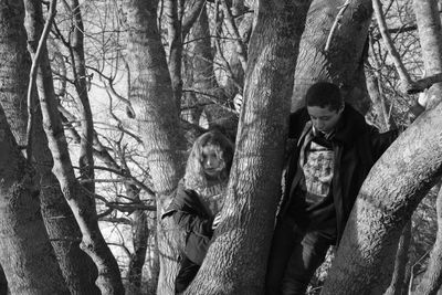 Men sitting on tree trunk in forest