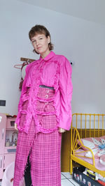 Portrait of woman standing against wall