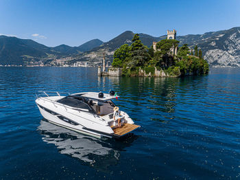 Boat moored on sea against blue sky